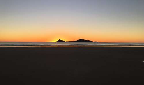 Sun Set Over A Hilly Island By the Coast Photo
