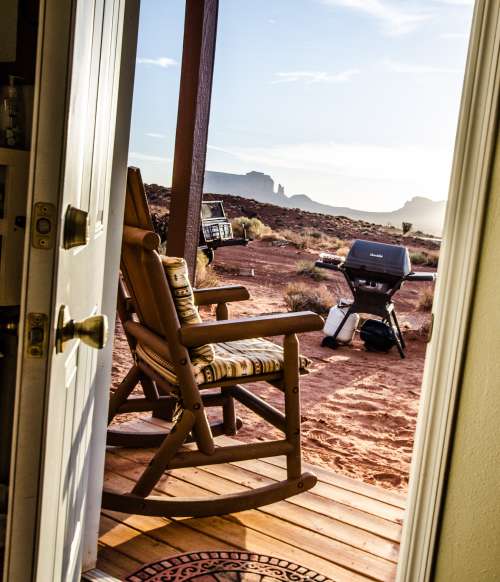 Through A Door A Rocking Chair On A Porch Overlooks The Desert Photo