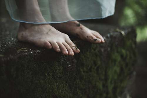 Two Dirty Feet On Mossy Ground Photo