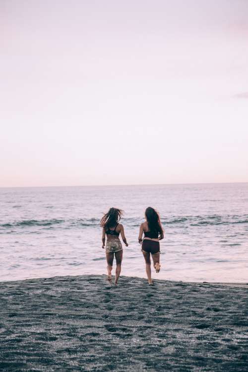 Two Women Run Along A Sunset Beach Photo