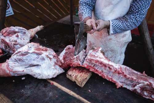 Butcher butchering a meat