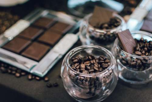 Dark chocolate bar and coffee beans in glasses