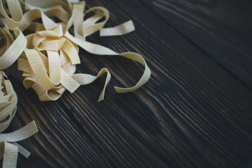 Detail of pasta tagliatelle on a wooden background