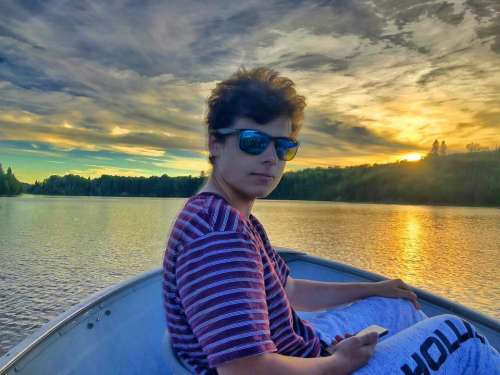 Man boy boating lake sunglasses 