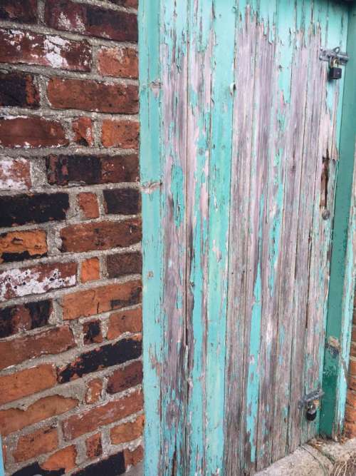 Turquoise flakey paint wooden door brick wall background