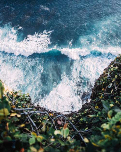 waves crashing rocks cliff ocean