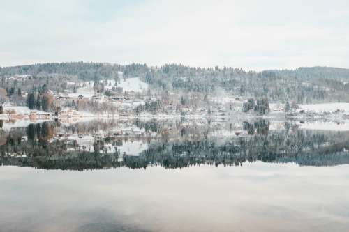 An Icy Lake Under Snowy And Snowy Hills under Frosty Sky Photo