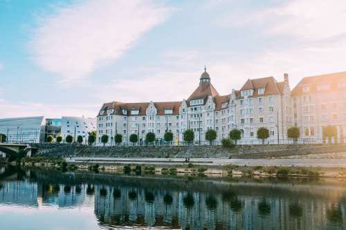 A Beautiful Building Reflected In A River Photo