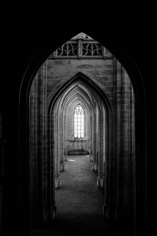 A Corridor Of Archways Leads To A Gothic Window Photo