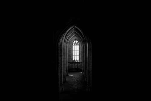 A Gothic Church Window Illuminates A Corridor Of Archways Photo