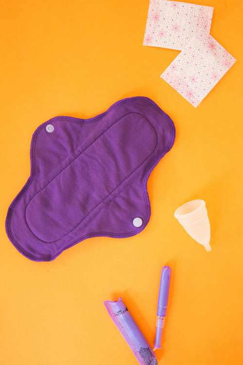 A Purple Reusable Menstrual Pad, Cup And Applicator Photo