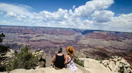 A Young Man And Woman Chat Over A Canyon Photo
