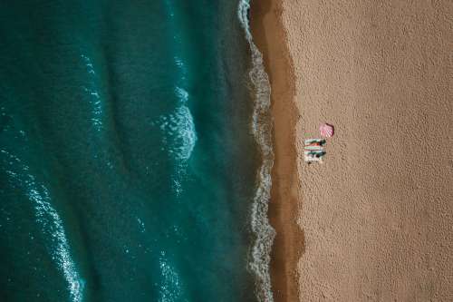 Aerial View Of Two Women Sitting On Sandy Beach Photo