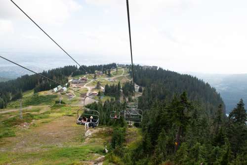 Happy Tourists On A Chairlift In The Mountains Photo