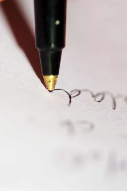 Closeup of pen point as writing flows