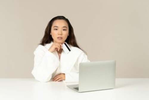 Young Asian Woman Looking Distracted While Doing Online Shopping