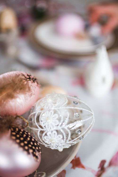 Easter table with cute pink decorations, flowers, catkins and eggs