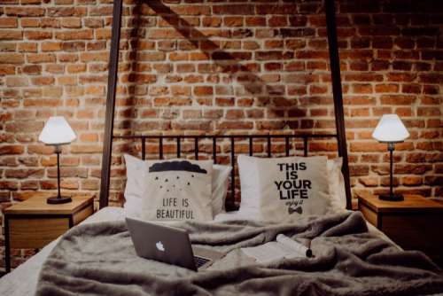 Enjoying evening with a Macbook in a nice bed
