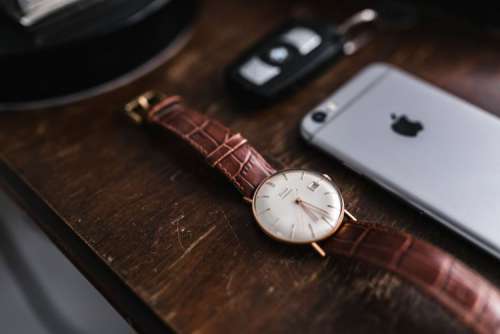 Apple iPhone 6 and Vintage watch on a brown leather wallet