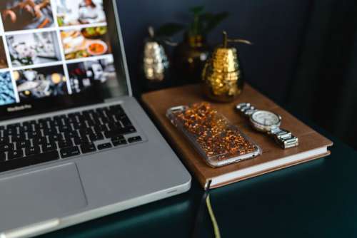 Home office desk with Macbook, iPhone, calendar, watch & organizer
