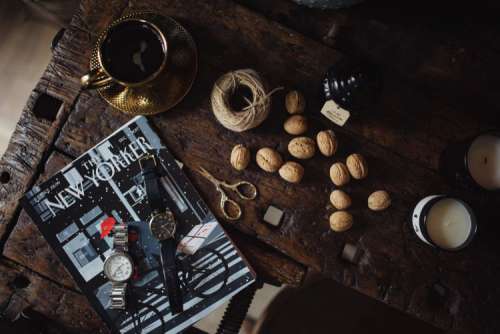 New Yorker, some nuts, watches, and other things on the old, wooden table