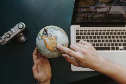 Male Finger Showing A Part Of The World On An Globe