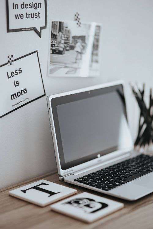 Inspirational cards with quotes, a black-and-white photo and a silver laptop