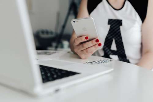 Businesswoman uses her mobile phone at her desk