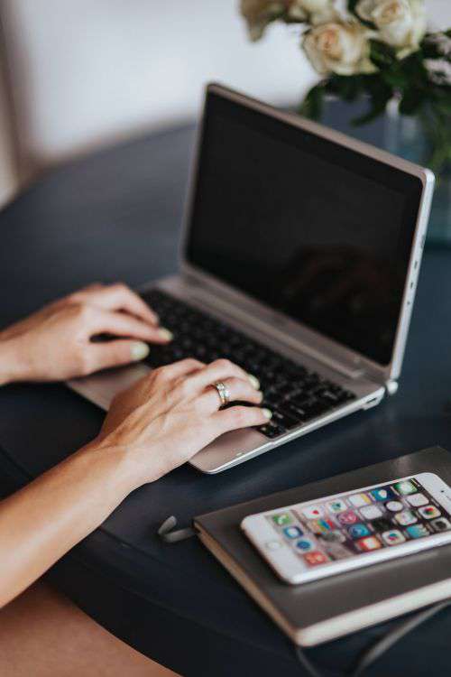 Woman using a laptop by a round breakfast table