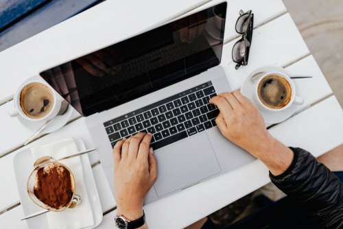 Working with a laptop by the sea. Cup of coffee and delicious tiramisu, Marina di Puolo, Italy