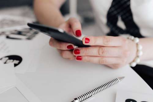 Businesswoman uses her mobile phone at her desk