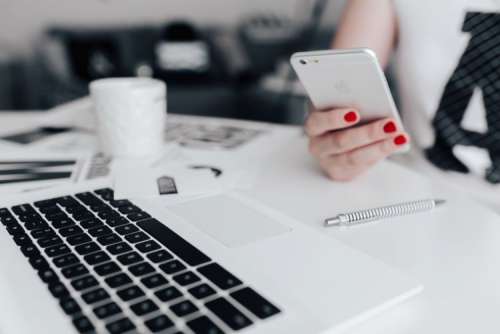 Businesswoman uses her mobile phone at her desk