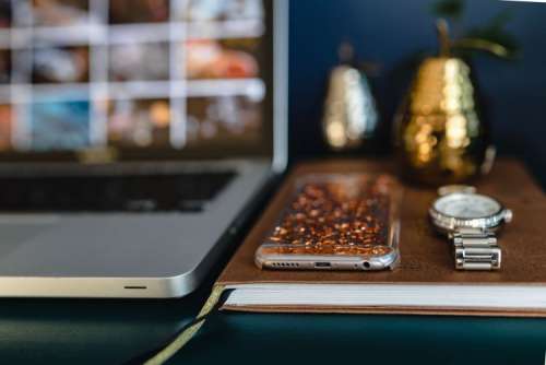 Home office desk with Macbook, iPhone, calendar, watch & organizer