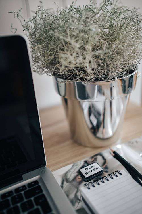 MacBook Pro with headphones on a wooden desk