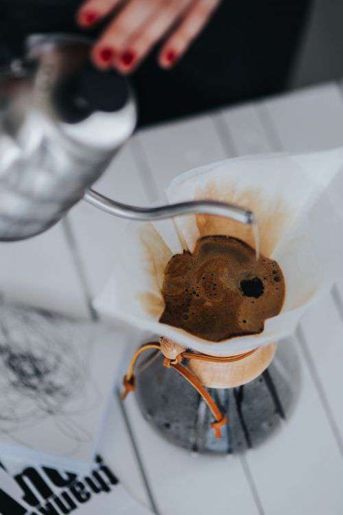 Woman pouring water in Chemex filter coffee maker