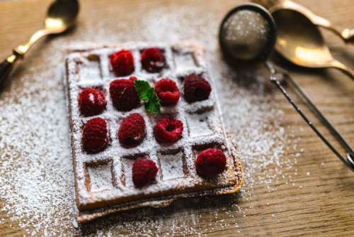 Breakfast waffles with fresh raspberries and powdered sugar