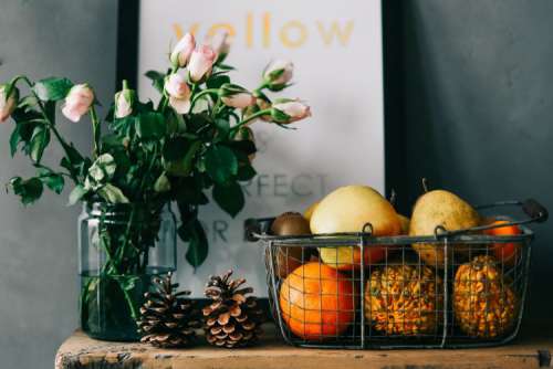 Assorted accessories with flowers and fruit on a shelf