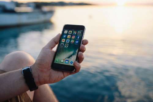 Mobile phone in man's hands near the sea