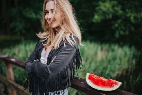 Blonde woman having a healthy snack at the wooden pier