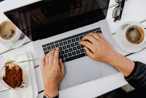 Working with a laptop by the sea. Cup of coffee and delicious tiramisu, Marina di Puolo, Italy