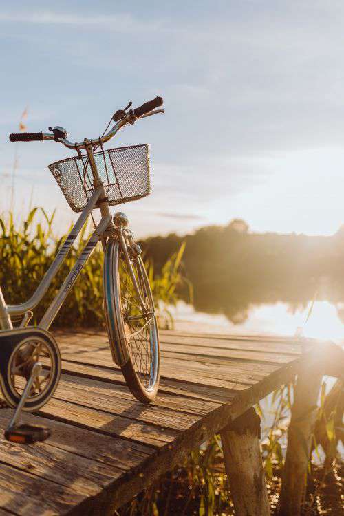 Bicycle with basket on the pier in bright sunset light
