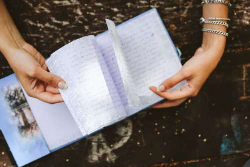 Woman reading a diary by the table