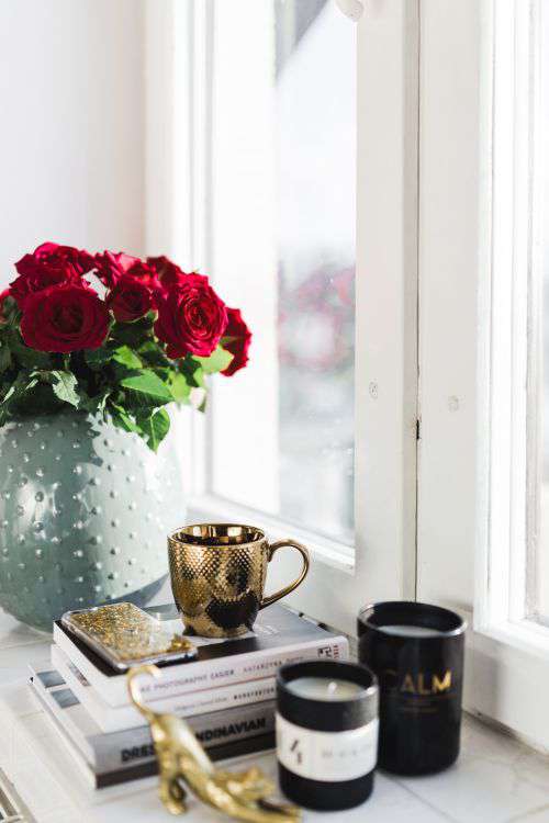 Gold cup of coffee and red roses bouqet