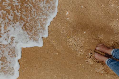 Sand beach background with sea shells & pebbles - many round small stones