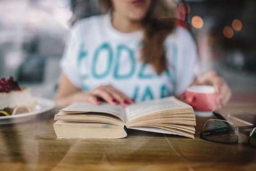 Woman reading book at coffee shop