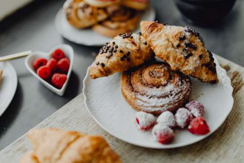 Croissants, puff pastry, powdered sugar and raspberries