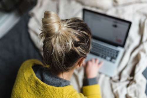 Blond using her laptop at her bedroom