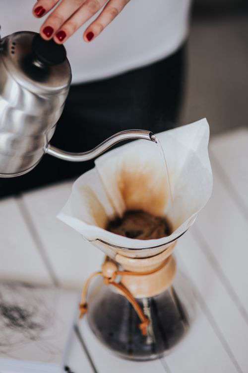 Woman pouring water in Chemex filter coffee maker