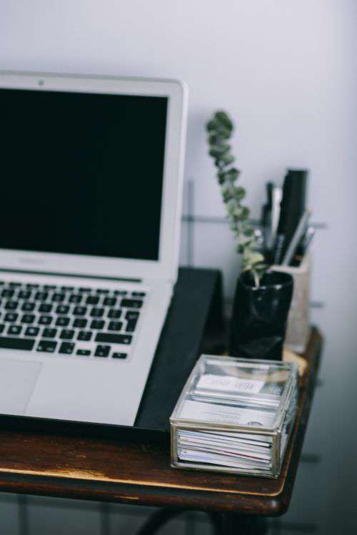 Elegant workspace with Macbook, iPhone, business cards and notebooks