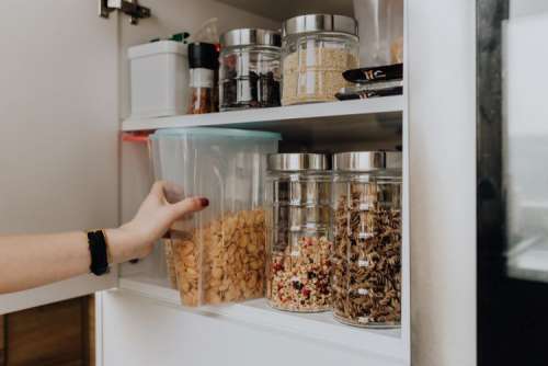 Containers of cereals in kitchen cupboard